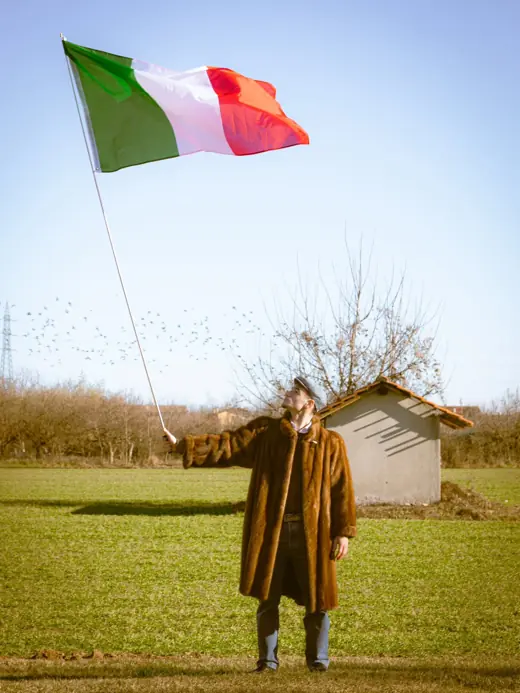 Figura in cappotto con bandiera italiana nel campo